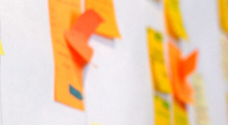 Close-up of colourful sticky notes on a planning wall, representing the early ideas and structure behind a company retreat agenda.