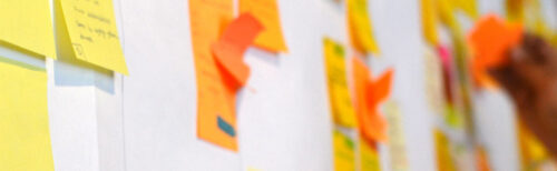 Close-up of colourful sticky notes on a planning wall, representing the early ideas and structure behind a company retreat agenda.