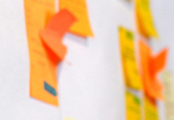Close-up of colourful sticky notes on a planning wall, representing the early ideas and structure behind a company retreat agenda.