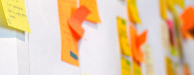 Close-up of colourful sticky notes on a planning wall, representing the early ideas and structure behind a company retreat agenda.