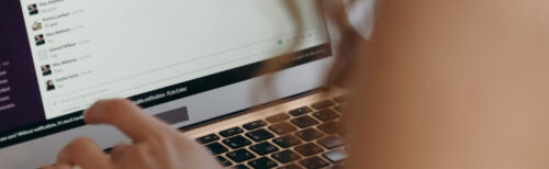Employee using a laptop and messaging platform while coordinating a 1-2-4-All discussion activity.