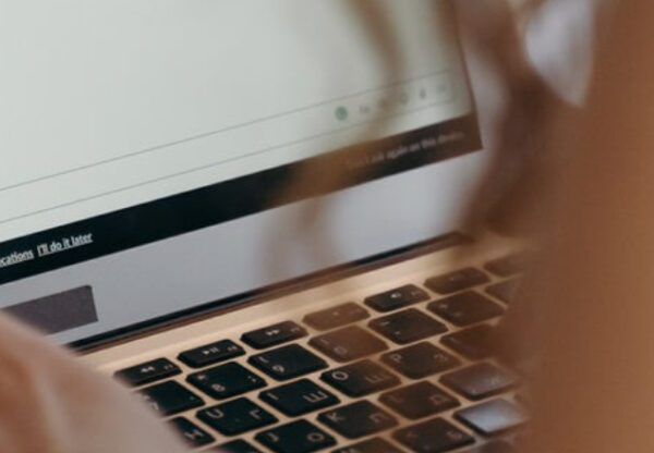 Employee using a laptop and messaging platform while coordinating company retreat planning and team communication activities.